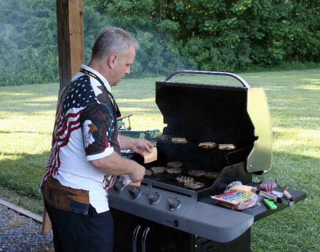 Tom cooks the cheeseburgers